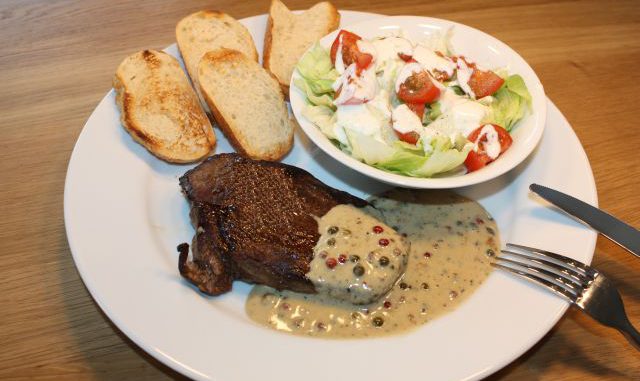 Zartes Rinder-Hüftsteak mit Pfeffersauce, geröstetem Baguette und Salat